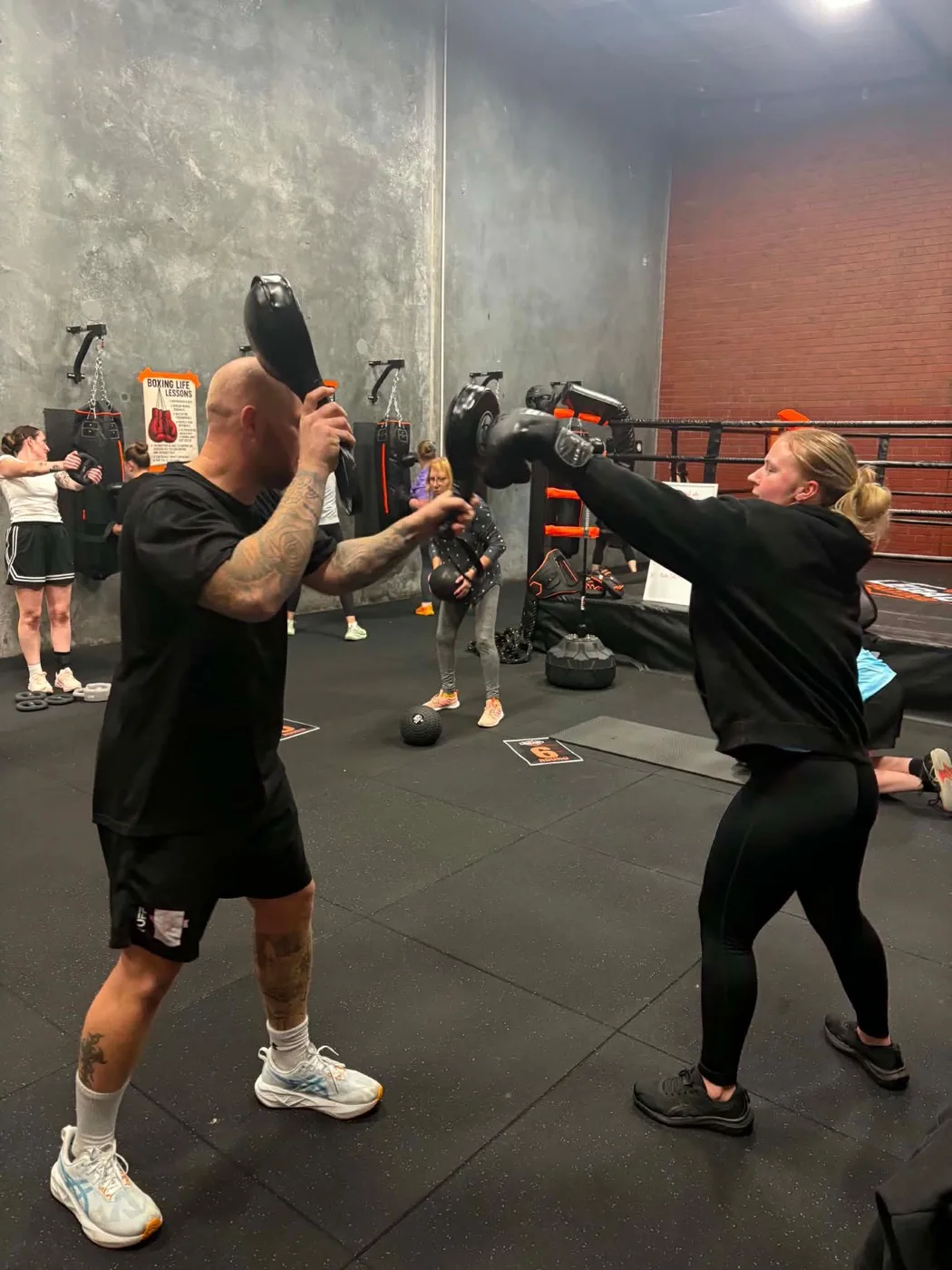 Coach doing pad work with female boxer at Legacy Boxing Grovedale